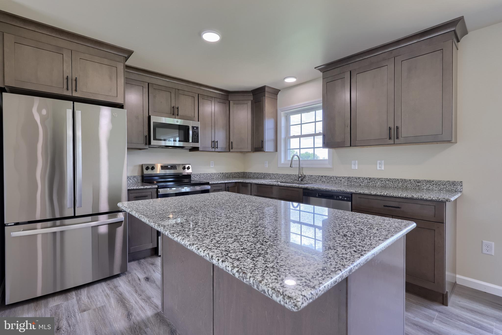 6030 Deborah Drive Spring Grove, PA 17362 - Photo 14 of 34 a kitchen with kitchen island granite countertop stainless steel appliances a sink stove refrigerator and a window