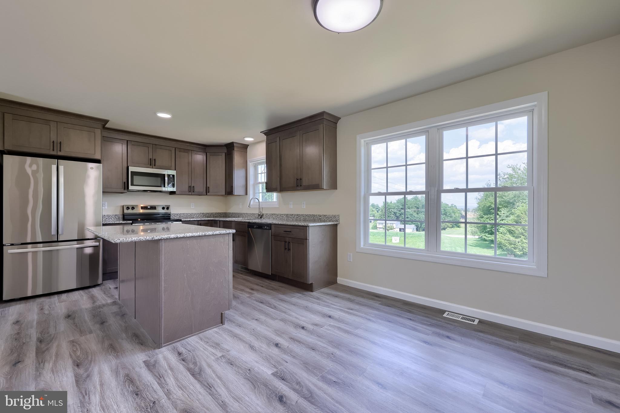 6030 Deborah Drive Spring Grove, PA 17362 - Photo 9 of 34 a kitchen with stainless steel appliances granite countertop a refrigerator a sink dishwasher a stove with wooden floors and cabinets
