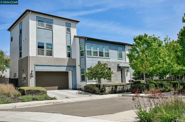 a front view of a house with yard and parking
