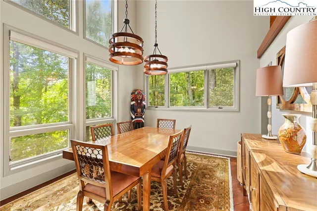a dining room with furniture a chandelier and wooden floor