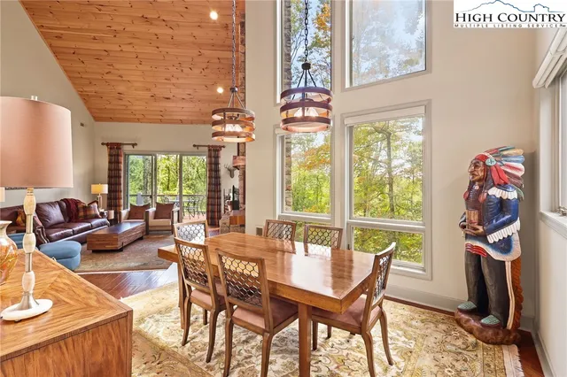 a dining room with furniture and a floor to ceiling window