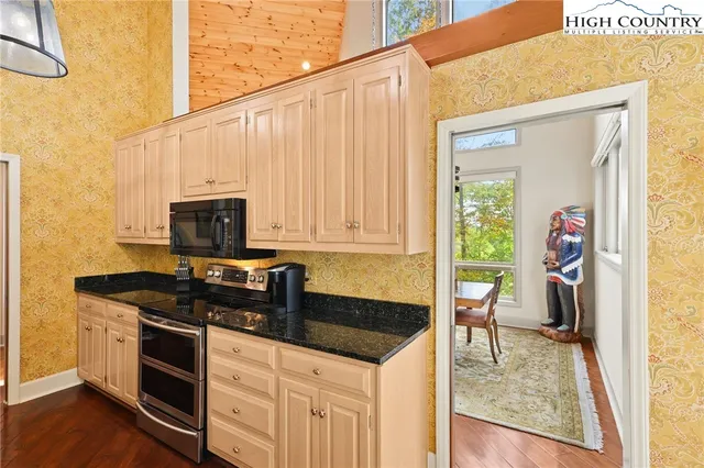 a kitchen with stainless steel appliances granite countertop a stove a sink and a microwave