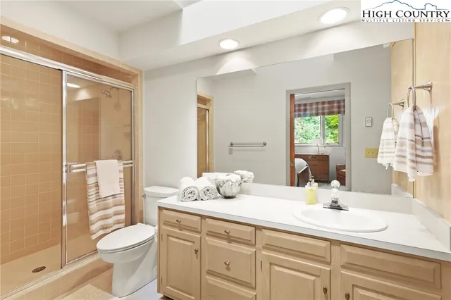 a bathroom with a double vanity sink toilet and shower