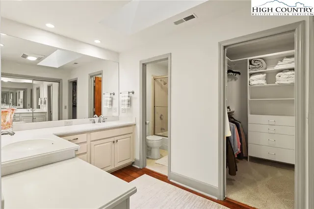 a large bedroom with a large bed mirror and vanity