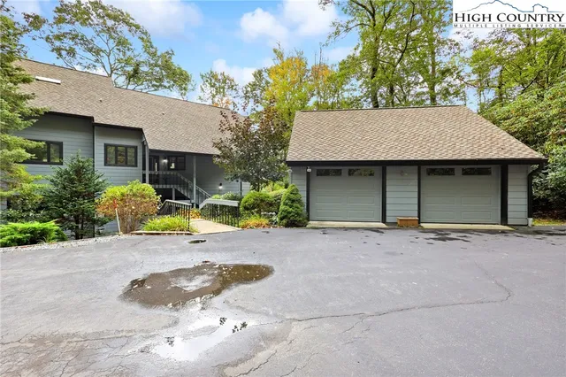 a front view of a house with a garden and a tree