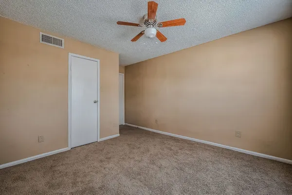 an empty room with a chandelier fan
