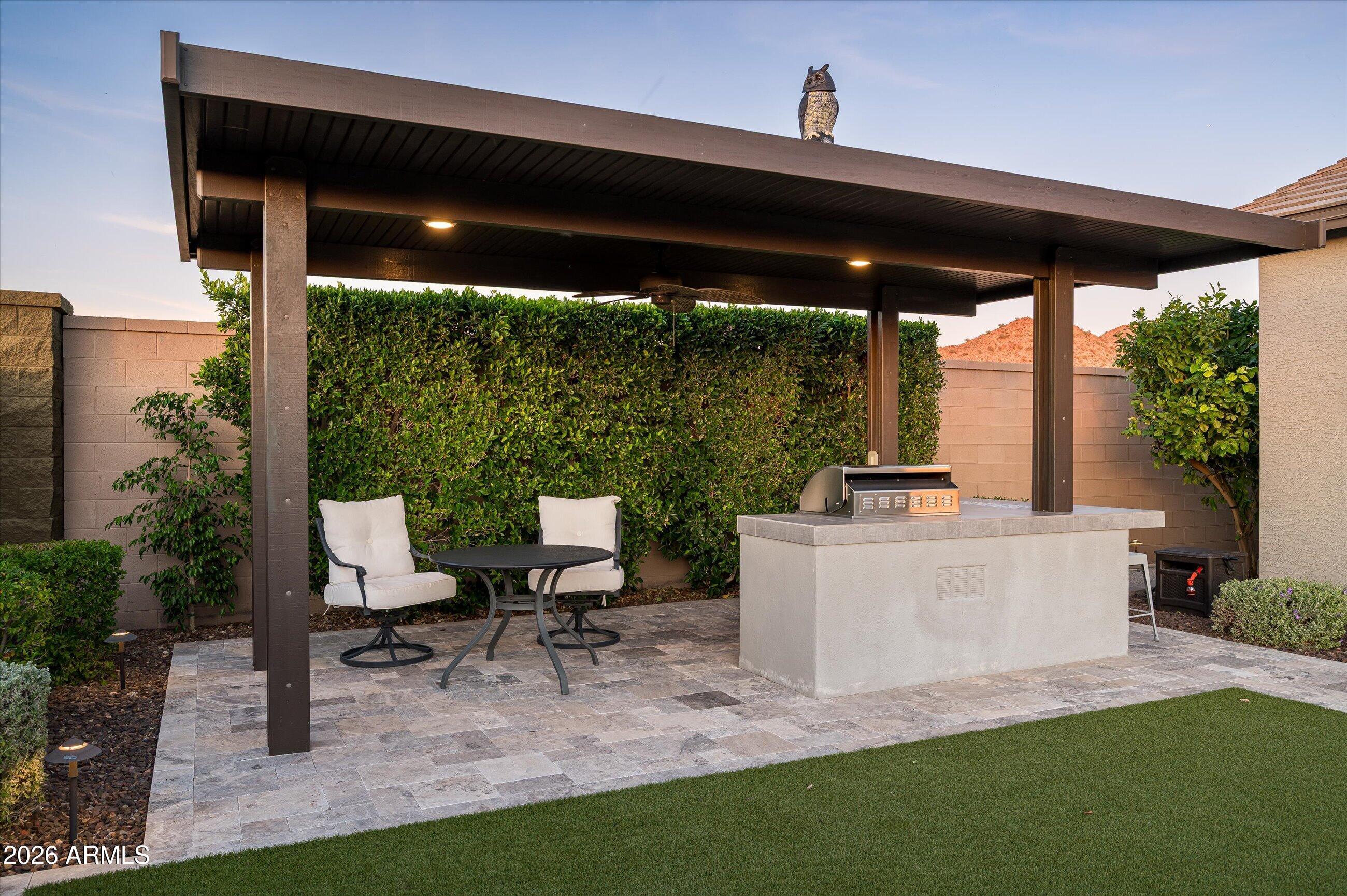 6406 Copper Springs Road Phoenix, AZ 85083 - Photo 42 of 59 a view of a patio with table and chairs under an umbrella with a small yard