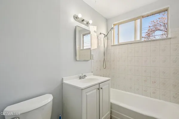 a bathroom with a sink mirror vanity and toilet