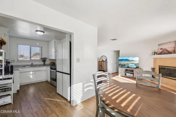 a kitchen with stainless steel appliances granite countertop a refrigerator oven a sink dishwasher and white cabinets with wooden floor