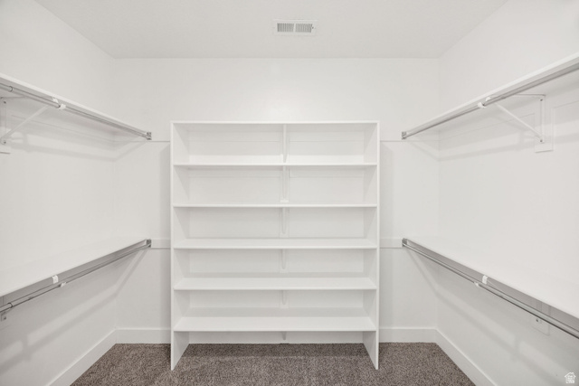 1552 Sumac Drive Logan, UT 84321 - Photo 50 of 72 Walk-in closet featuring built-in shelving, dual hanging rods, and neutral-toned carpeting