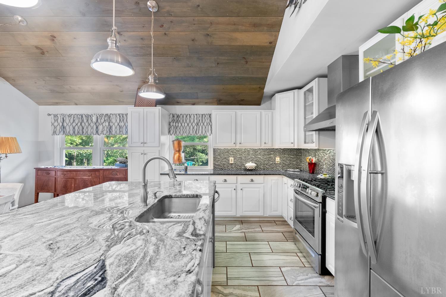 224 Sunset Drive Amherst, VA 24521 - Photo 11 of 34 a kitchen with stainless steel appliances granite countertop a refrigerator a sink dishwasher a stove a dining table and chairs with wooden floor