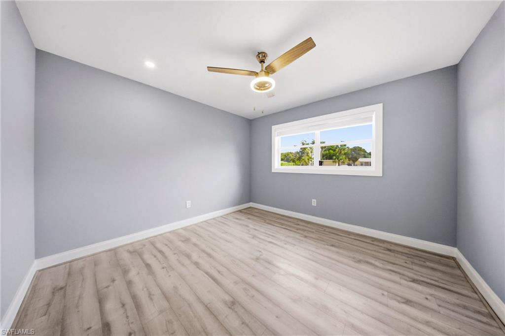 4375 Golden Gate Parkway Naples, FL 34116 - Photo 15 of 34 Empty room with wood finished floors and ceiling fan