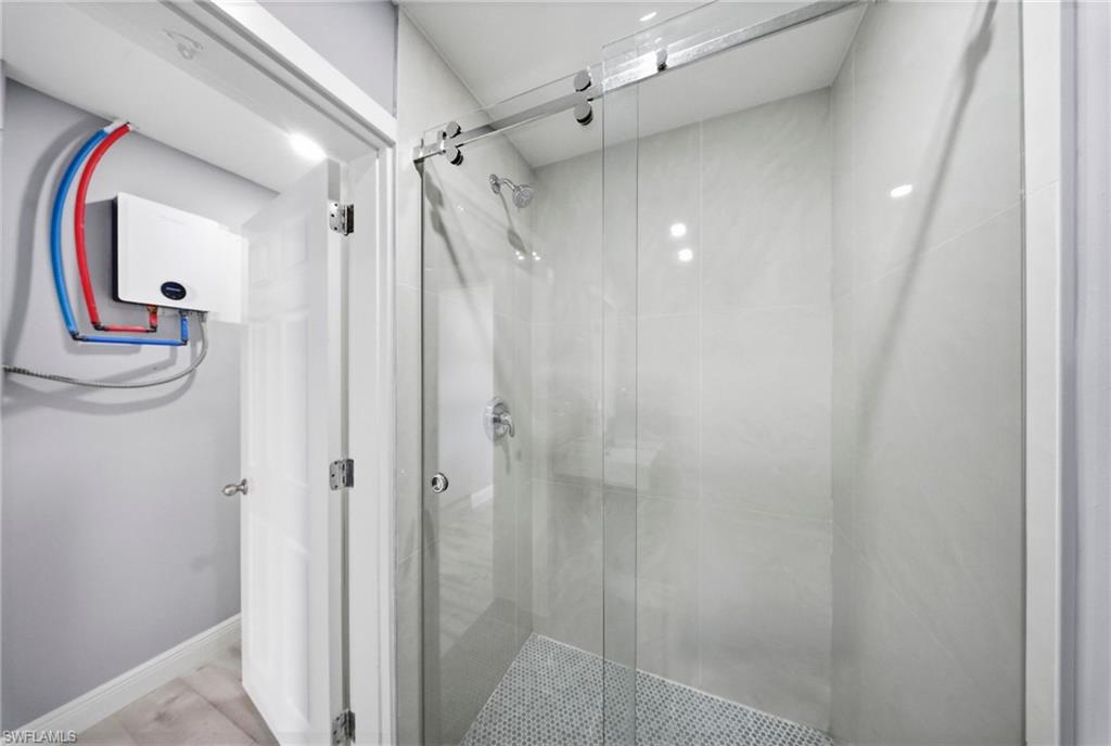 4375 Golden Gate Parkway Naples, FL 34116 - Photo 27 of 34 Bathroom with a shower stall and baseboards