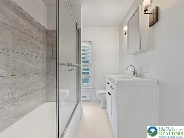 a bathroom with a sink a toilet and shower