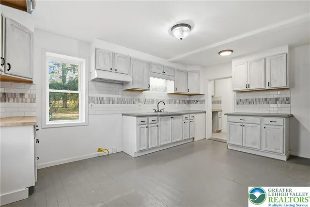 a kitchen with granite countertop white cabinets and white stainless steel appliances