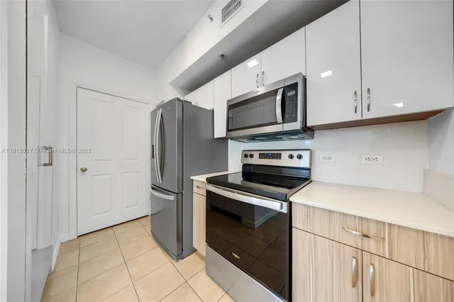 a kitchen with stainless steel appliances granite countertop a refrigerator microwave and sink