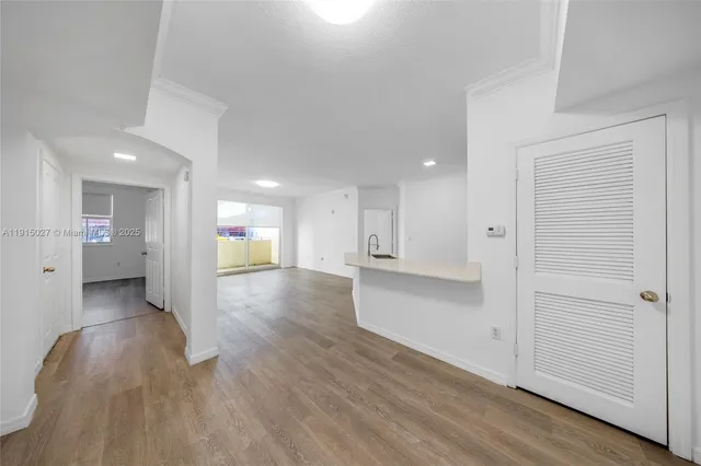 a view of a hallway with wooden floor and a cabinet