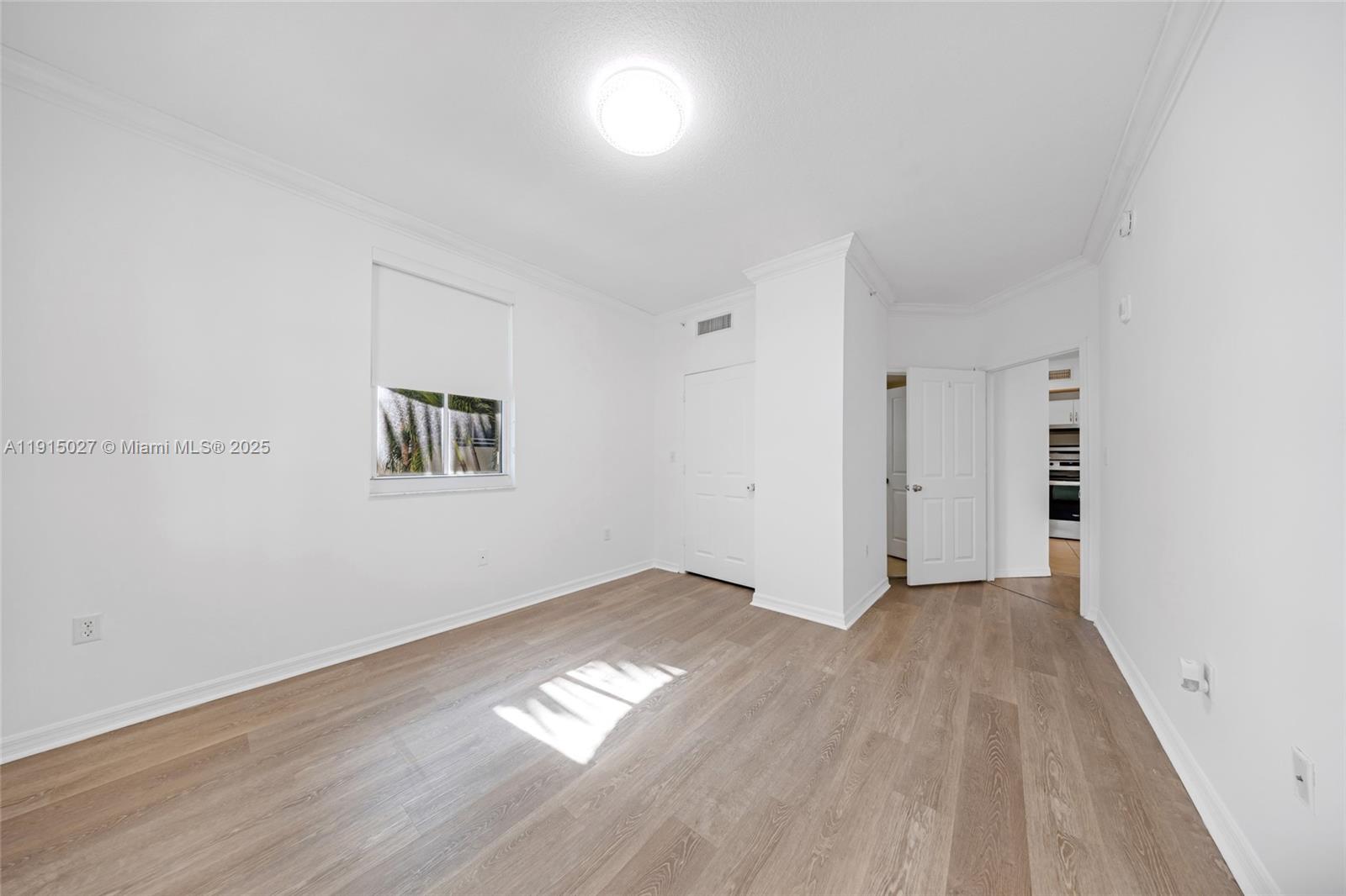 9172 Collins Avenue, Unit 212 Surfside, FL 33154 - Photo 2 of 31 an empty room with wooden floor and windows