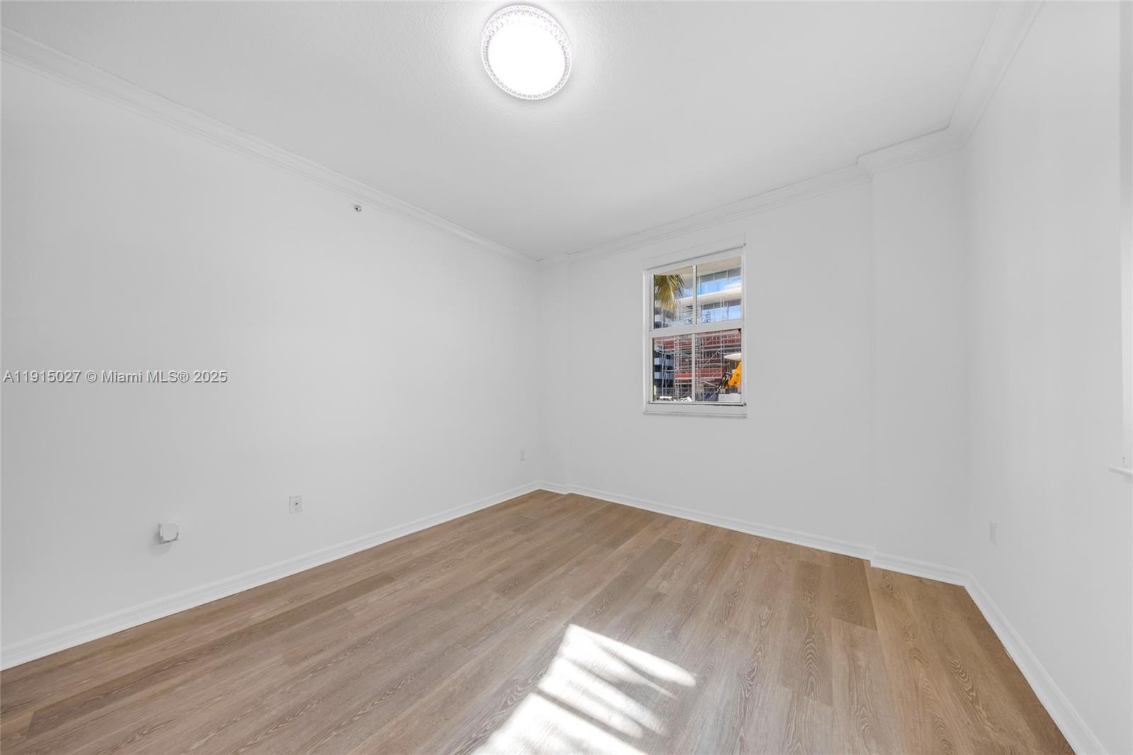9172 Collins Avenue, Unit 212 Surfside, FL 33154 - Photo 3 of 31 an empty room with wooden floor and windows