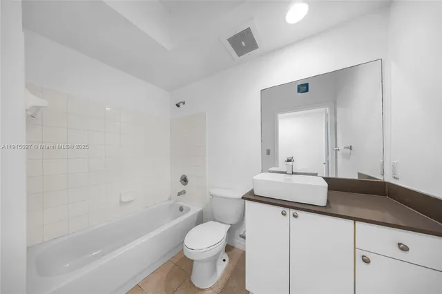 a bathroom with a granite countertop sink a toilet and a bathtub