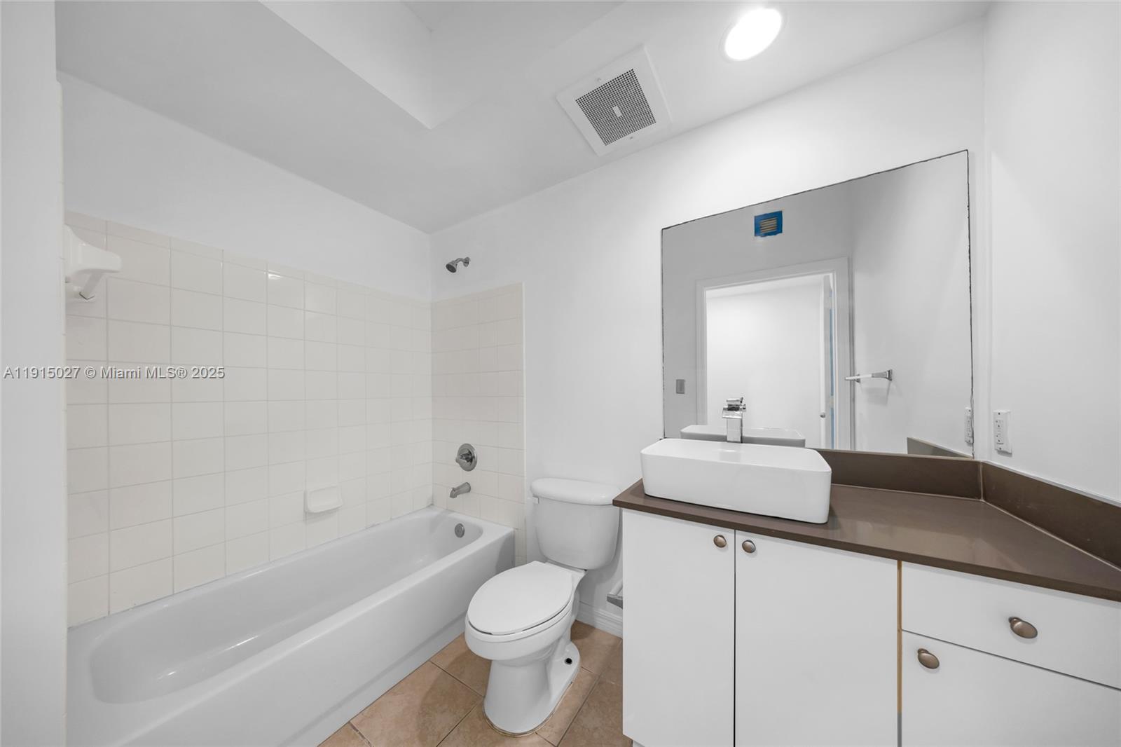 9172 Collins Avenue, Unit 212 Surfside, FL 33154 - Photo 7 of 31 a bathroom with a granite countertop sink a toilet and a bathtub