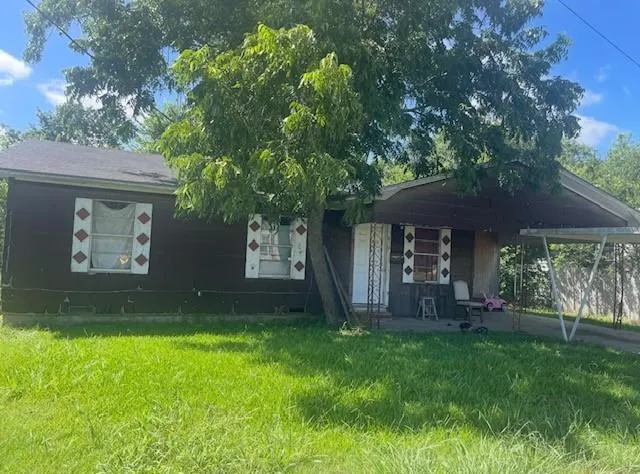 a view of a house with a yard and tree
