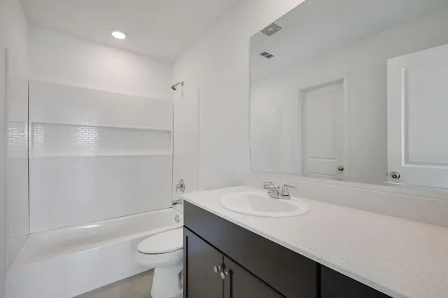 a bathroom with a sink a toilet a shower and a mirror