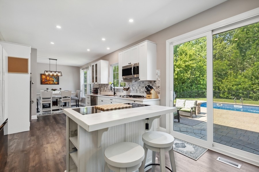 2415 Fen View Circle Island Lake, IL 60042 - Photo 9 of 27 a kitchen with a table chairs stove and cabinets