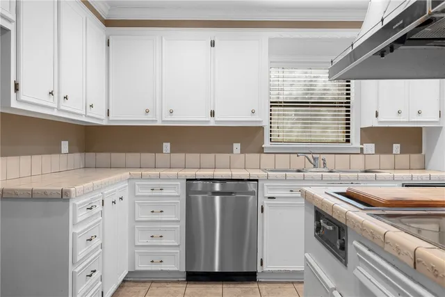 a kitchen with cabinets appliances a sink and a window