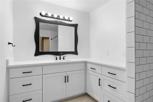 a bathroom with a sink vanity and mirror