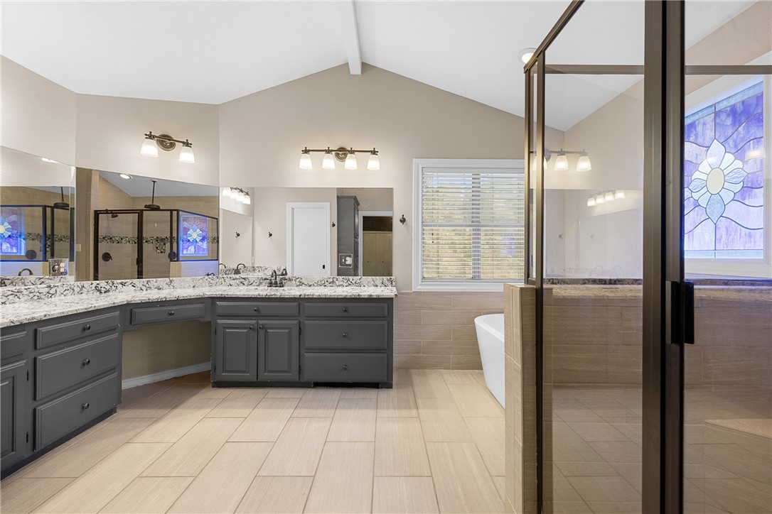 1027 Shadylane Drive Lexington, TX 78947 - Photo 27 of 45 a large bathroom with a granite countertop double vanity sink a mirror and a shower