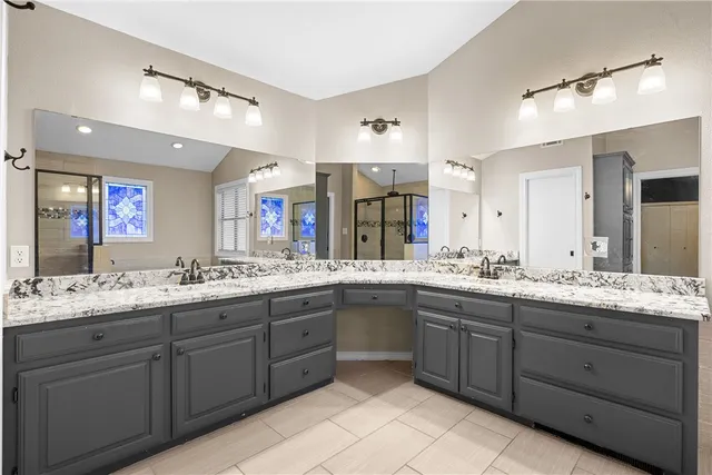 a bathroom with a granite countertop sink double and mirror
