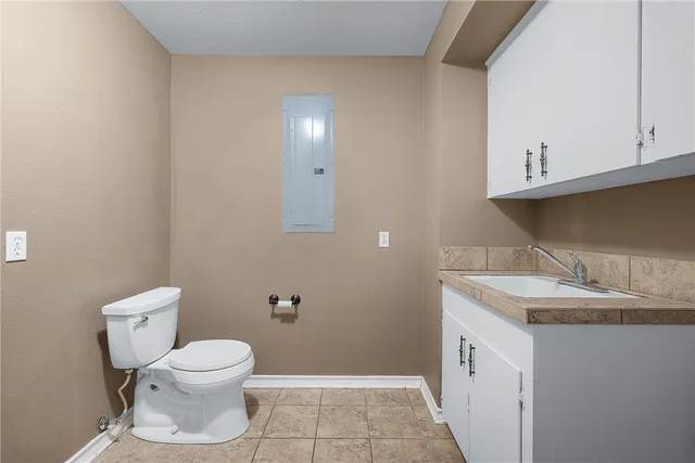 a bathroom with a granite countertop toilet and sink