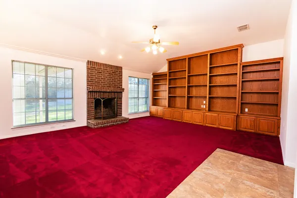 a view of empty room with a fireplace and window