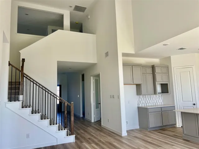 a view of a hallway with wooden floor and staircase