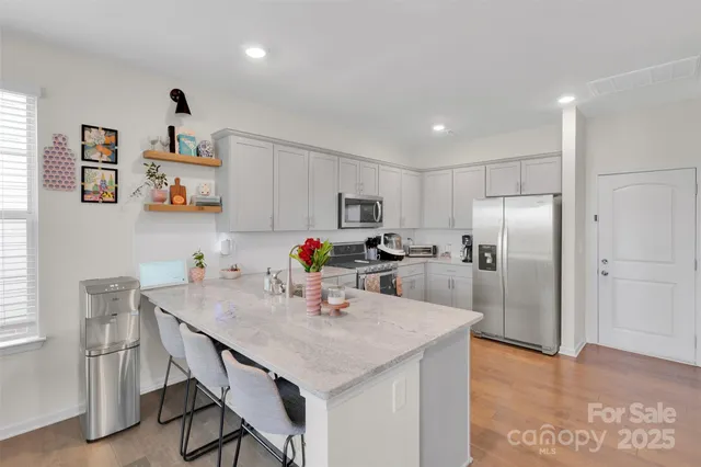 a kitchen with kitchen island a refrigerator stove and microwave