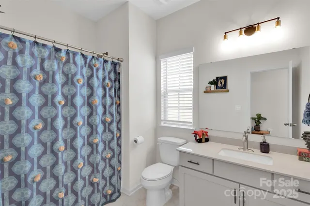 a bathroom with a granite countertop sink a toilet and a mirror