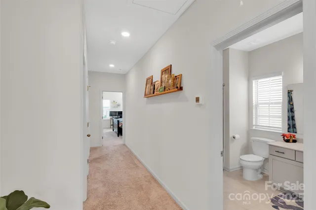 a view of a hallway with toilet and a window