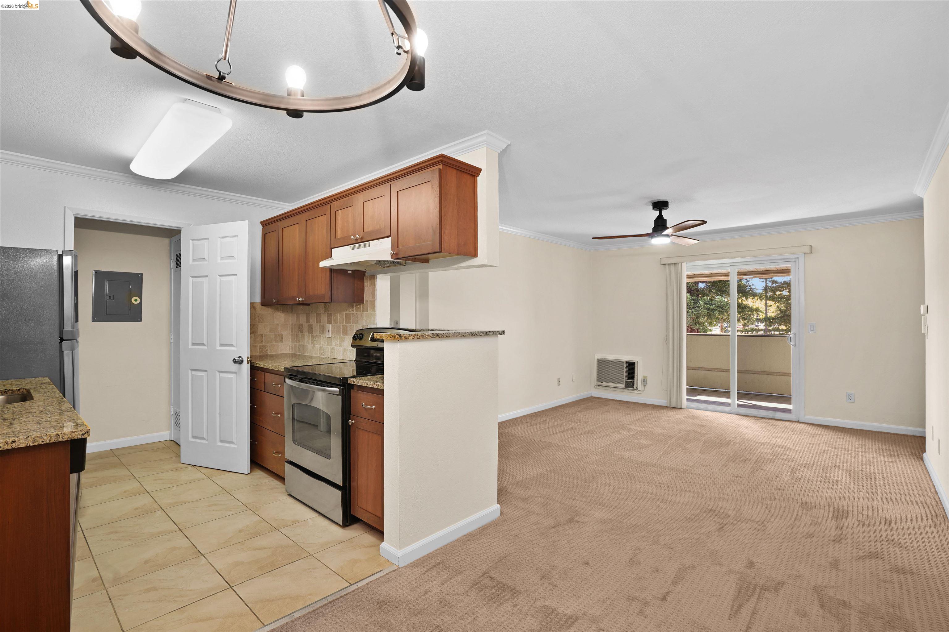 1505 Kirker Pass Road, Unit 214 Concord, CA 94521 - Photo 12 of 55 Open-concept living space featuring a kitchen with wood cabinetry, stainless steel appliances, and a tiled backsplash