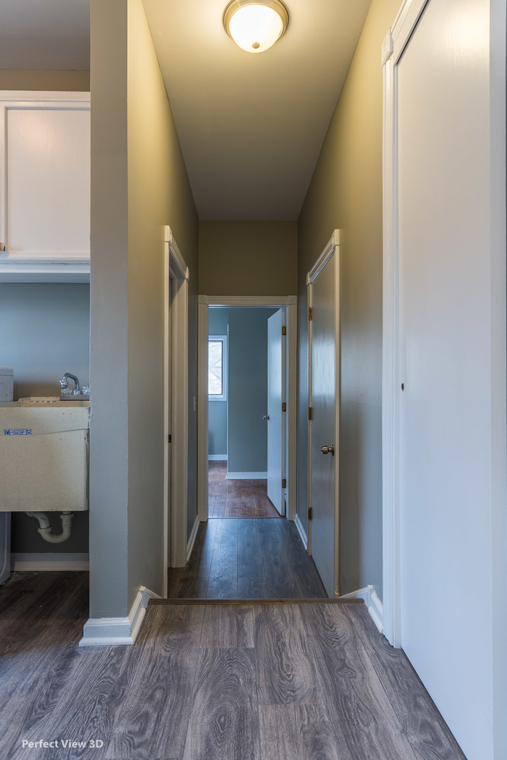 1100 West Seil Road Shorewood, IL 60404 - Photo 15 of 30 a view of a hallway with wooden floor and a bathroom