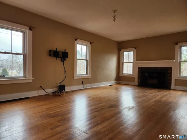 an empty room with floor to ceiling windows and a fireplace