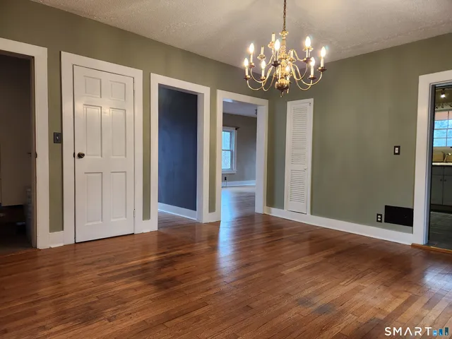 a view of a big room with wooden floor and chandelier