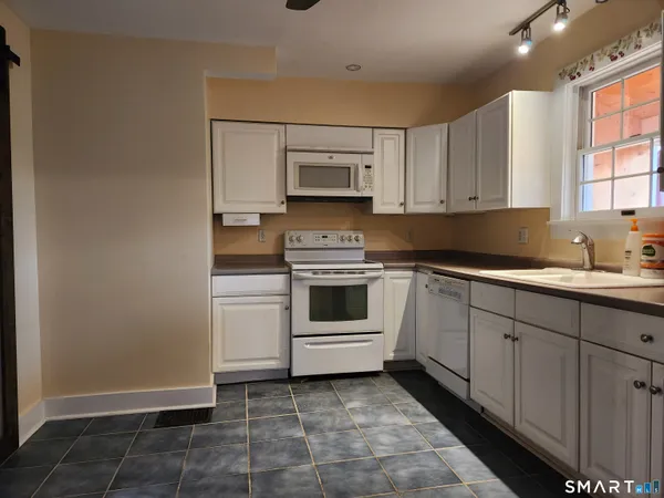 a kitchen with a stove and white cabinets