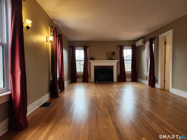 a view of an empty room with window and fire place