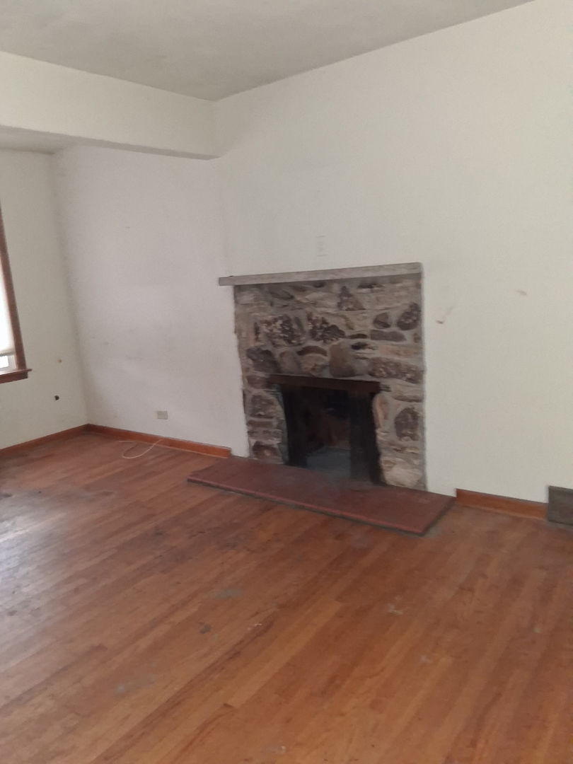 213 South Summit Street Wheaton, IL 60187 - Photo 8 of 33 an empty room with wooden floor and fireplace
