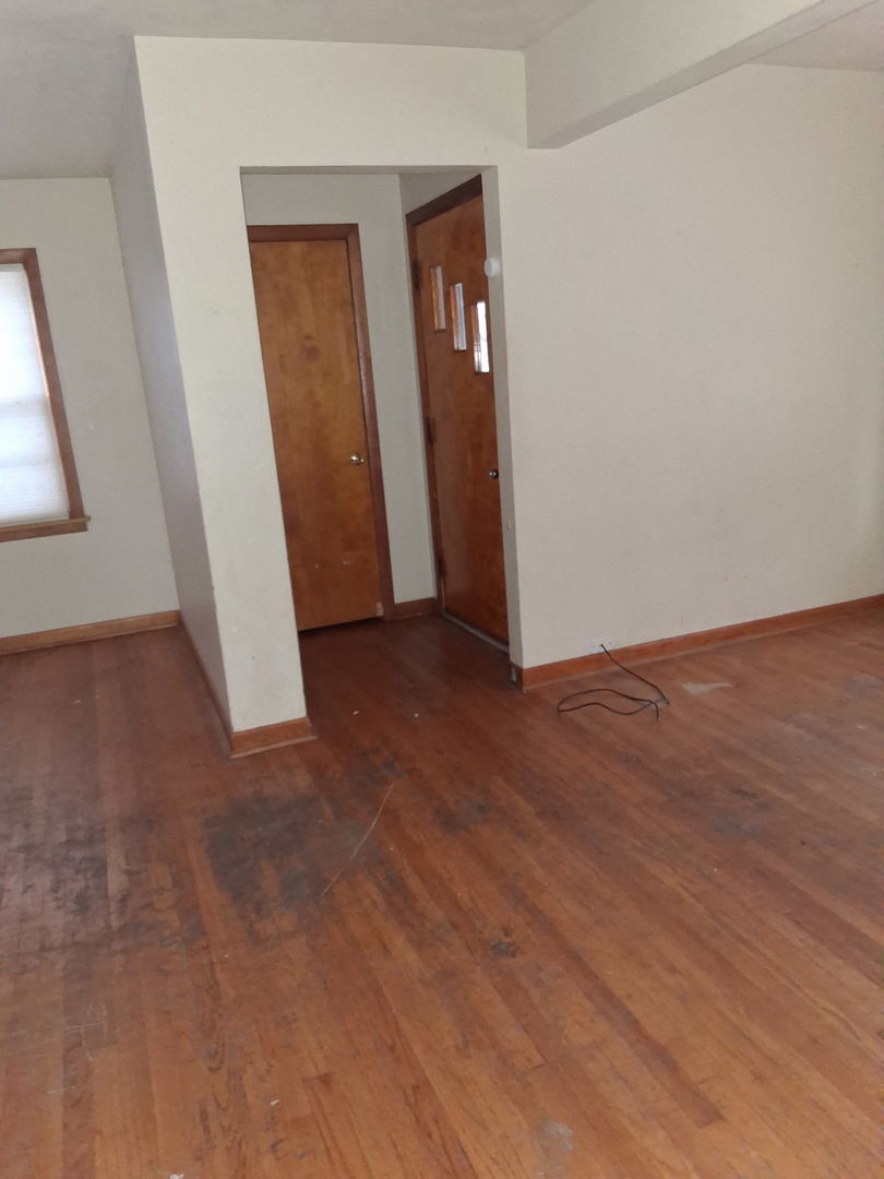 213 South Summit Street Wheaton, IL 60187 - Photo 10 of 33 an empty room with wooden floor and mirror