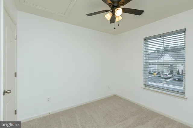 an empty room with closet and a chandelier fan