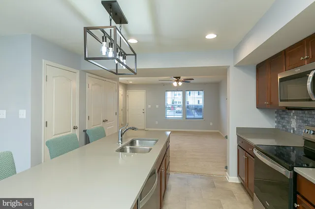 a kitchen with stainless steel appliances granite countertop a sink dishwasher a stove a microwave oven with a dining table and chairs