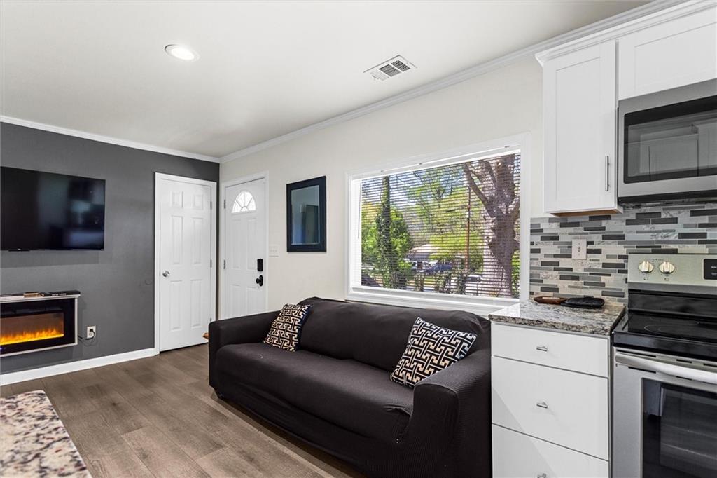 1111 Valley View Road Southeast Atlanta, GA 30315 - Photo 2 of 31 a living room with stainless steel appliances furniture a flat screen tv and a window