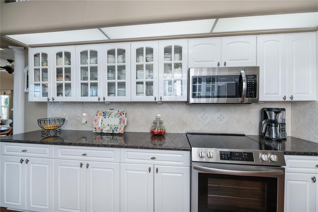 26373 Madagascar Road Punta Gorda, FL 33983 - Photo 25 of 90 a kitchen with stainless steel appliances granite countertop a stove microwave and cabinets
